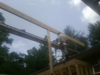 Carpenter setting a ridge beam over a new addition frame — Ice Dam Removal by Roofing Brothers in Spring Park