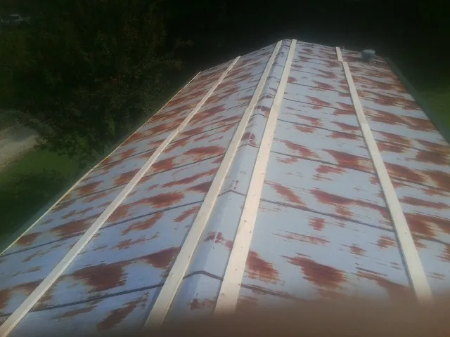 Rusted metal roof panels with new wood purlins before replacement — Storm Damage Roof Repair in Spring Park by Roofing Brothers